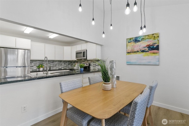 dining room with light wood-type flooring and baseboards