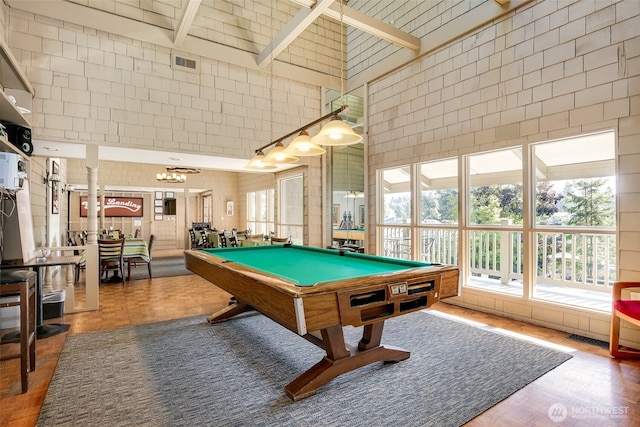 game room with a towering ceiling, visible vents, tile walls, and pool table