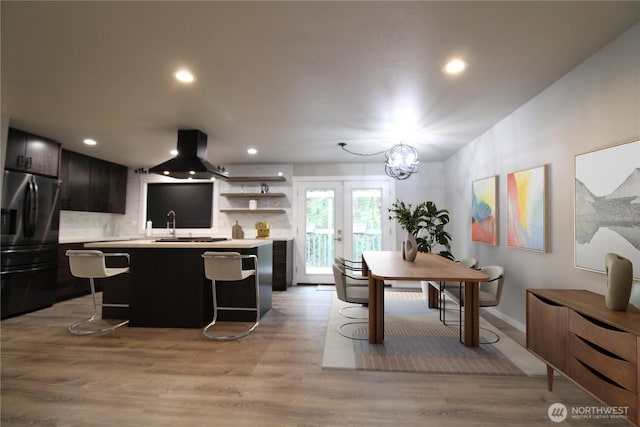 dining room featuring sink, french doors, and light hardwood / wood-style flooring