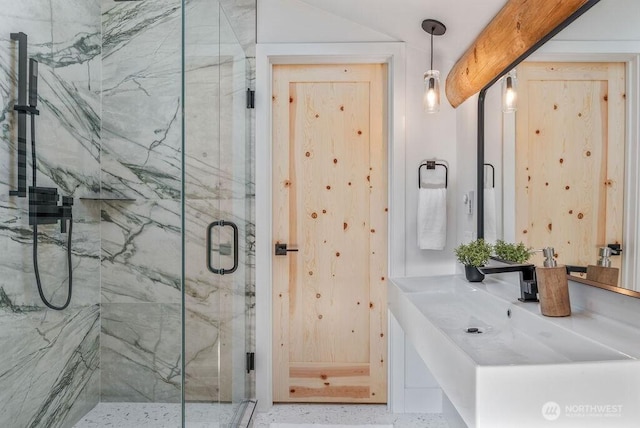 bathroom with a sink and a marble finish shower