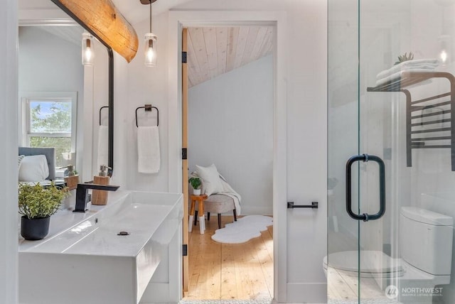 full bath featuring vaulted ceiling with beams, a shower stall, toilet, and wood finished floors