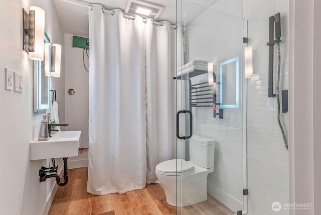 full bathroom with toilet, a shower stall, and wood finished floors