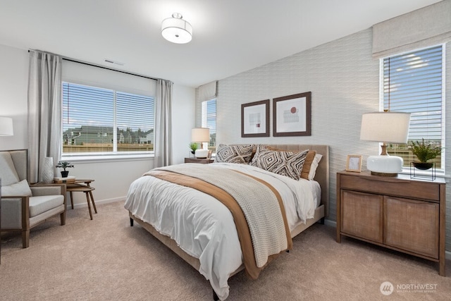 bedroom with light carpet and multiple windows