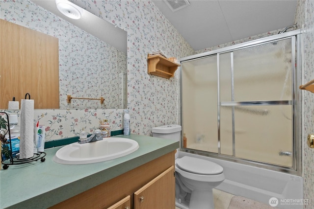 full bathroom with toilet, vanity, and bath / shower combo with glass door