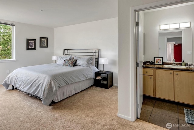 bedroom with sink and light colored carpet