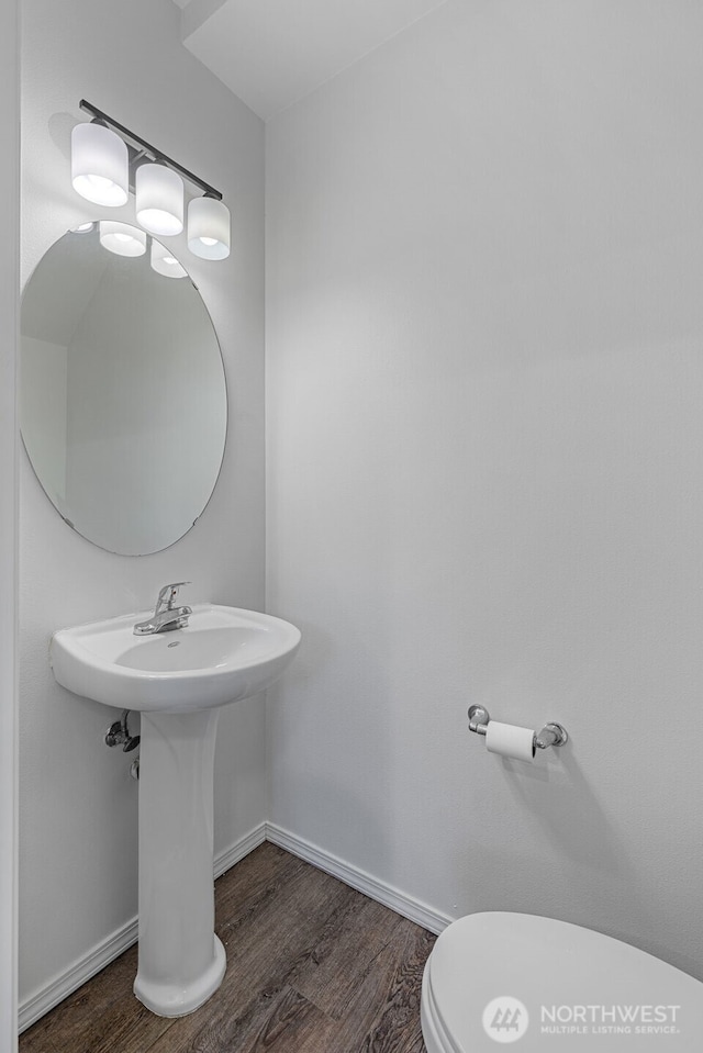 bathroom with hardwood / wood-style floors, sink, and toilet