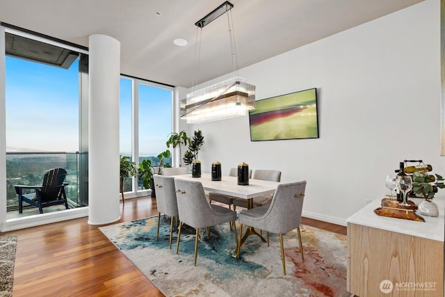 dining area with hardwood / wood-style flooring and a wall of windows