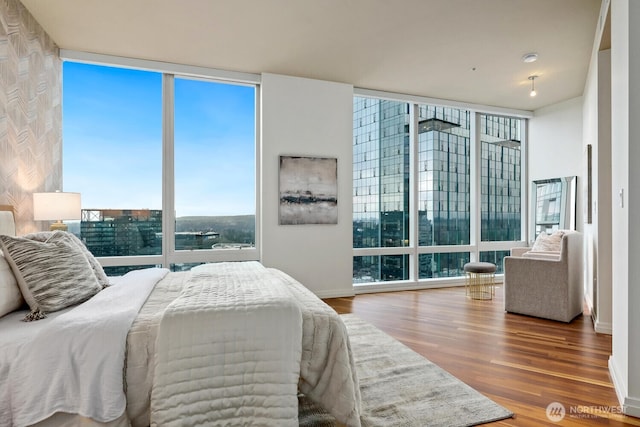 bedroom featuring expansive windows and hardwood / wood-style flooring