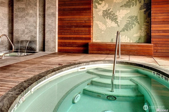 view of swimming pool with a wooden deck and an indoor hot tub