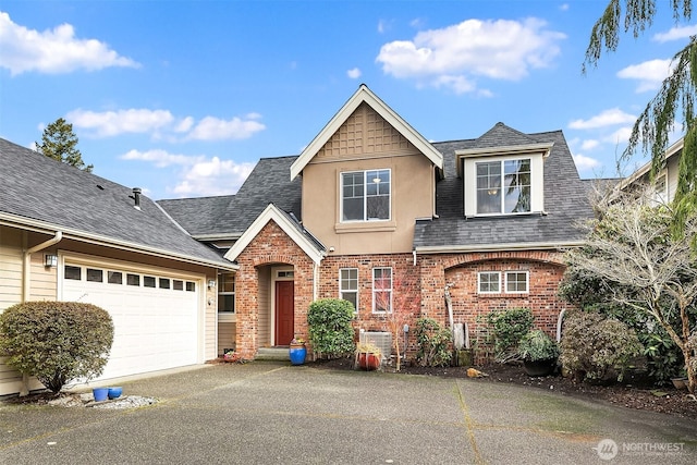 view of front of house featuring brick siding, roof with shingles, aphalt driveway, and stucco siding