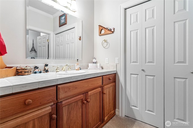 bathroom featuring ornamental molding, a closet, and vanity