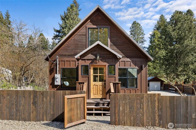 rustic home featuring a garage, fence, and board and batten siding