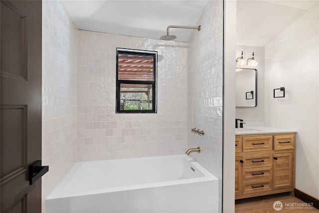 bathroom with baseboards, shower / bathing tub combination, wood finished floors, and vanity