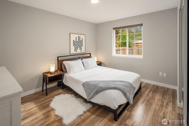 bedroom with baseboards and wood finished floors