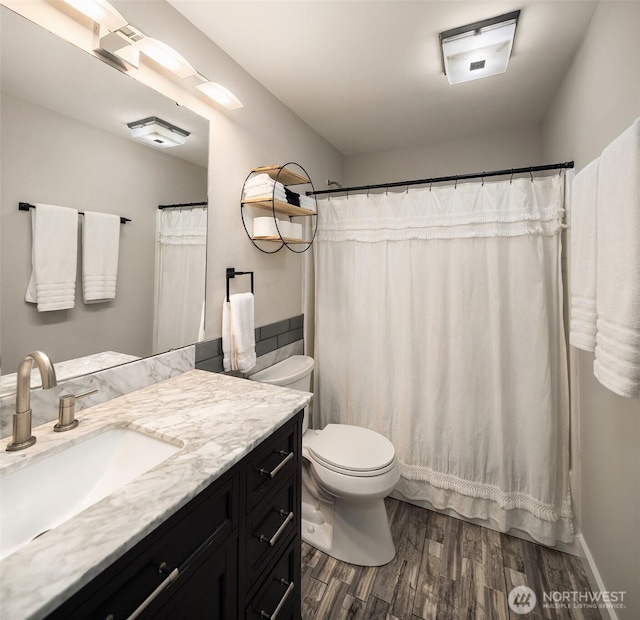 full bath with toilet, wood finished floors, and vanity