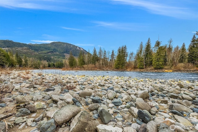 mountain view with a wooded view and a water view