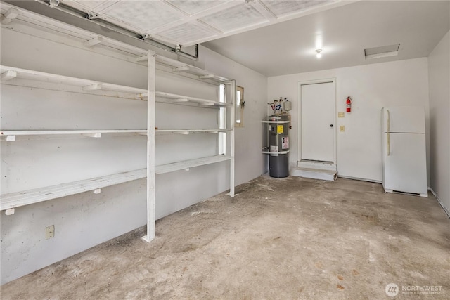 garage with strapped water heater and freestanding refrigerator