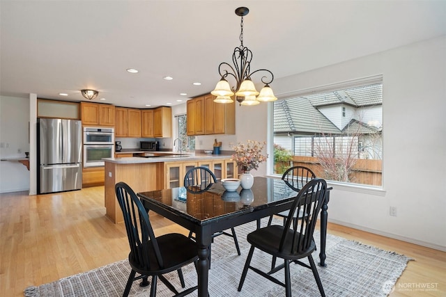 dining area featuring recessed lighting, baseboards, light wood finished floors, and a chandelier