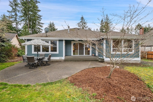 back of house with entry steps, a shingled roof, a patio, and fence