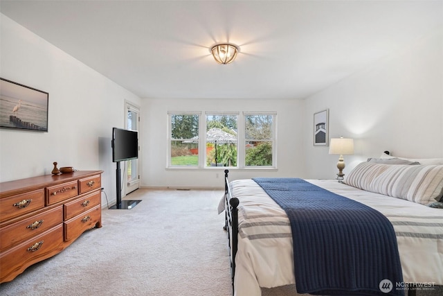 bedroom featuring baseboards and light carpet