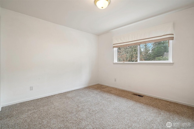 carpeted spare room with visible vents and baseboards