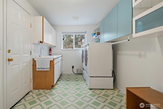 laundry area featuring visible vents, a sink, cabinet space, light floors, and washer / dryer