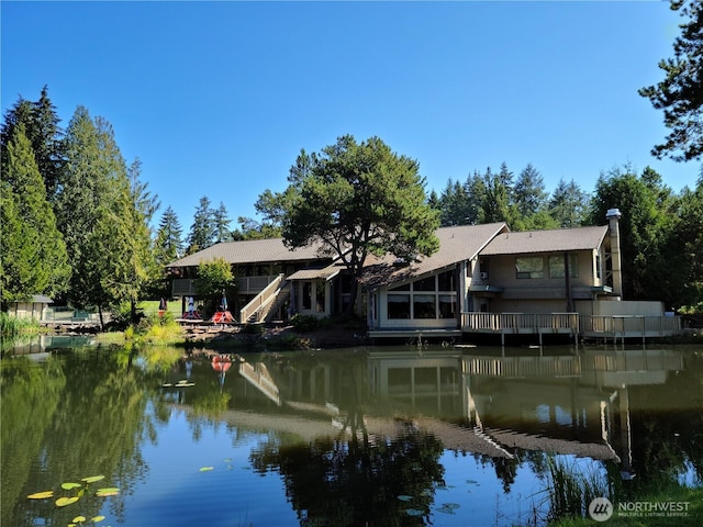 back of property featuring a water view