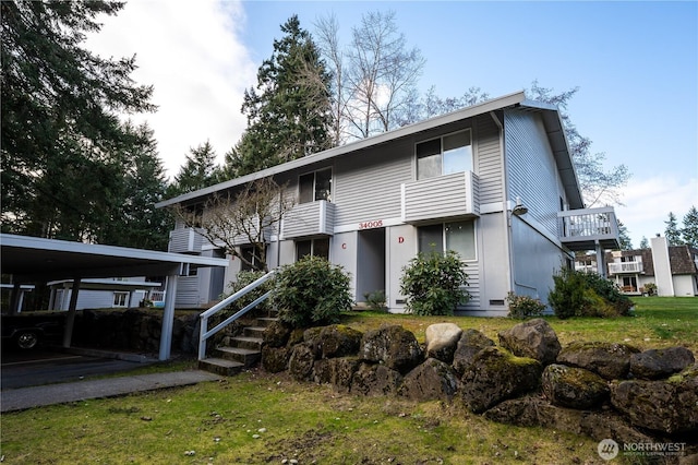 view of property featuring a carport and a front yard