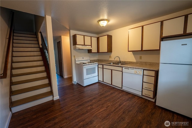 kitchen with dark wood-style floors, a sink, white appliances, under cabinet range hood, and baseboards