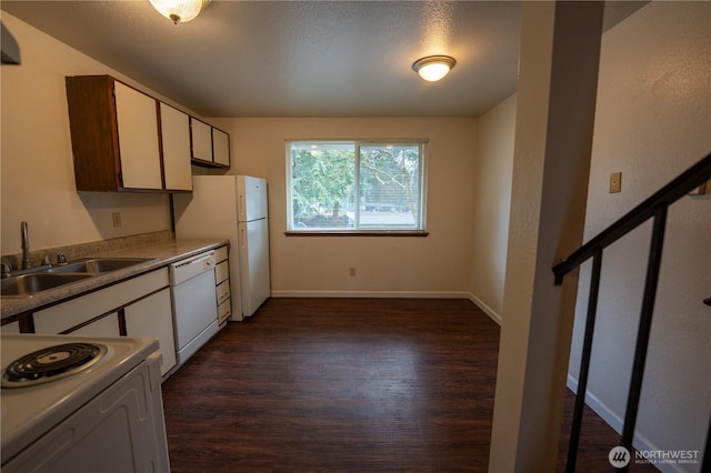 kitchen featuring white appliances, a sink, baseboards, light countertops, and dark wood-style floors