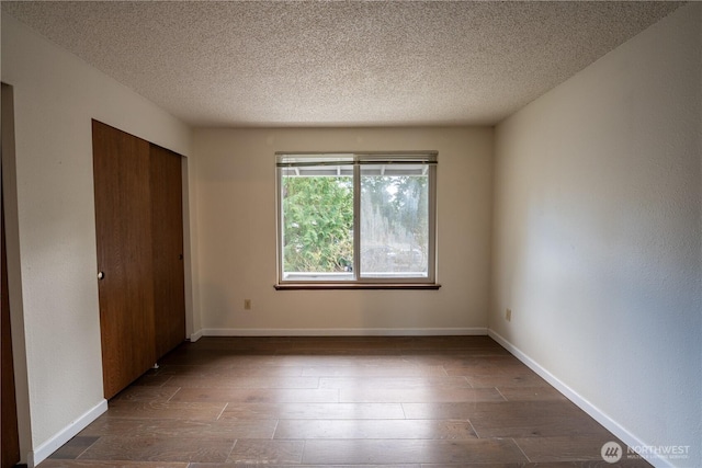 unfurnished bedroom featuring baseboards and dark wood-style flooring