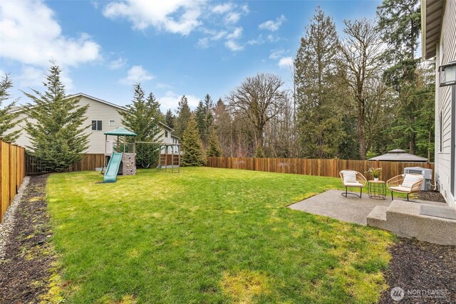 view of yard featuring a playground and a patio