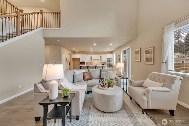 living room featuring light wood-type flooring and a high ceiling