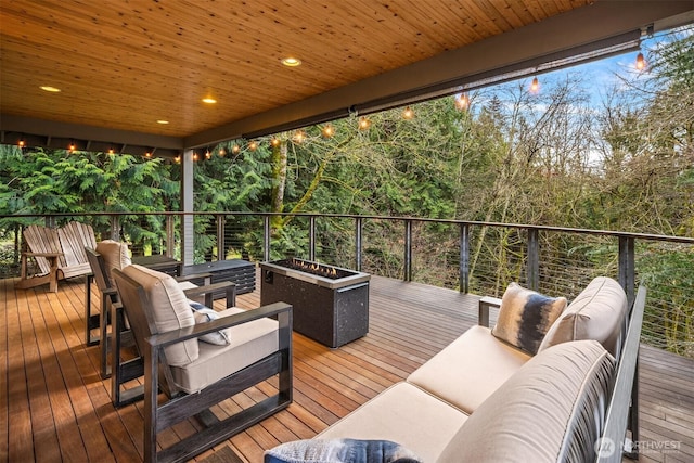 wooden terrace with an outdoor living space with a fire pit