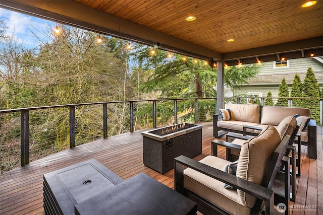 wooden deck with an outdoor living space with a fire pit