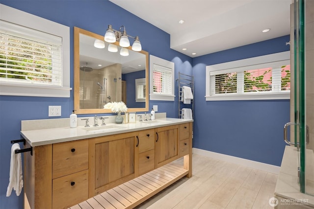 bathroom with wood-type flooring, vanity, and walk in shower