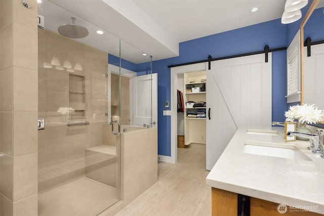 bathroom featuring wood-type flooring, a shower with shower door, and vanity