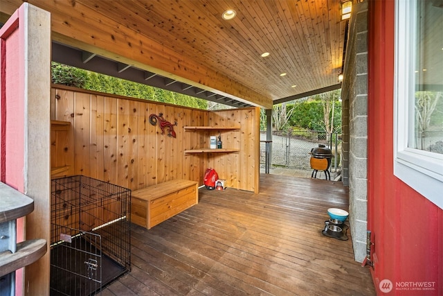 mudroom with wooden walls, plenty of natural light, dark wood-type flooring, and wooden ceiling