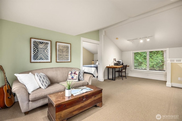 carpeted living room with rail lighting and vaulted ceiling