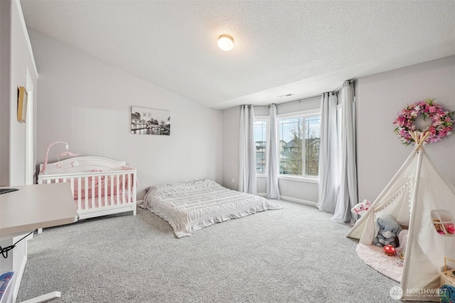 carpeted bedroom with vaulted ceiling and a textured ceiling