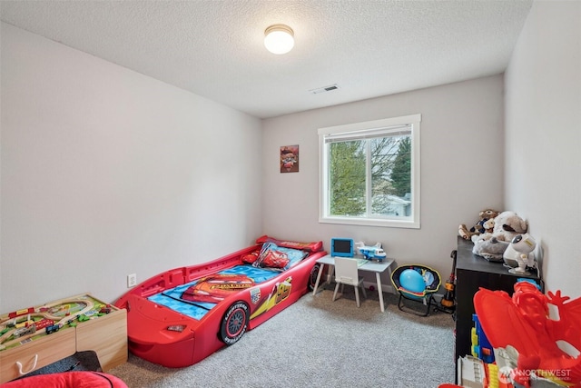 bedroom featuring carpet floors, visible vents, and a textured ceiling