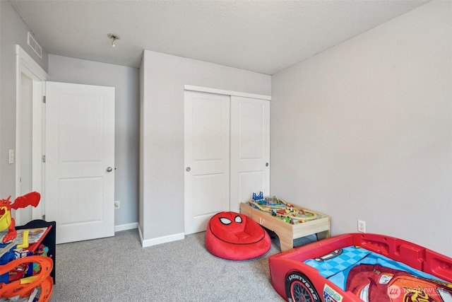 carpeted bedroom featuring baseboards, a textured ceiling, visible vents, and a closet