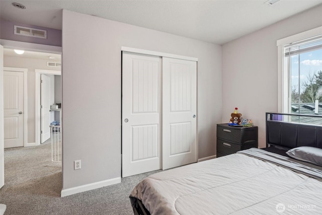 bedroom with a closet, carpet, visible vents, and baseboards