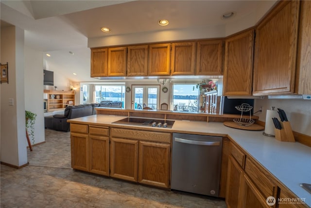 kitchen with black electric cooktop, brown cabinets, stainless steel dishwasher, and light countertops