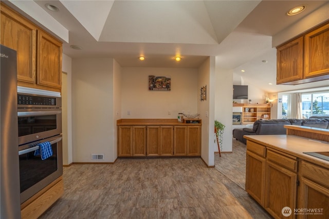 kitchen with recessed lighting, visible vents, brown cabinets, and stainless steel double oven