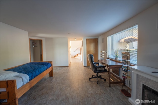 bedroom with a fireplace and baseboards