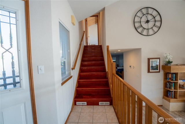 stairway with tile patterned floors and visible vents