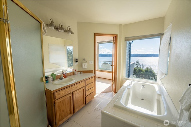 full bathroom featuring a bath, vanity, and a water view