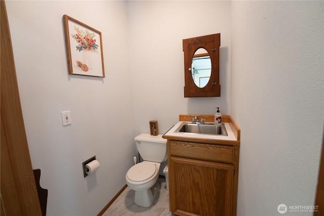 half bathroom featuring vanity, tile patterned floors, and toilet