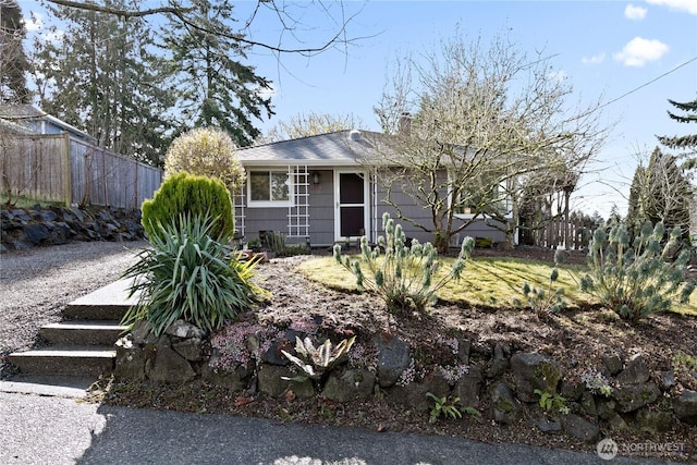 view of front of home with a chimney and fence